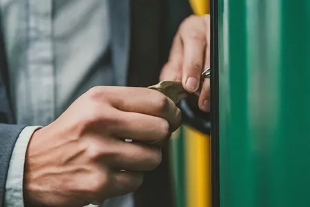 A man's hands unlocking a storage unit lock.